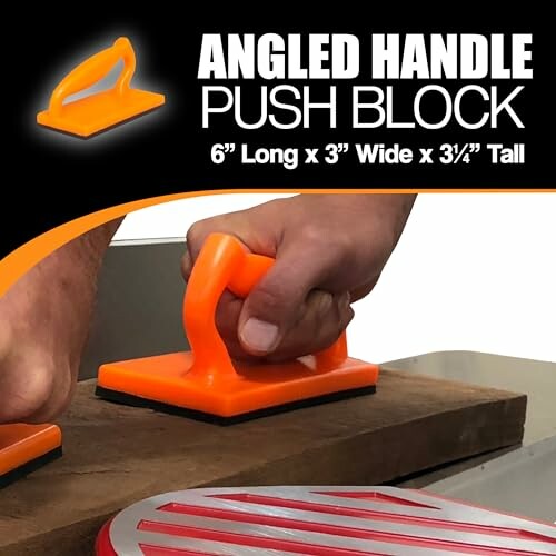 Orange angled handle push block in use on wood surface.