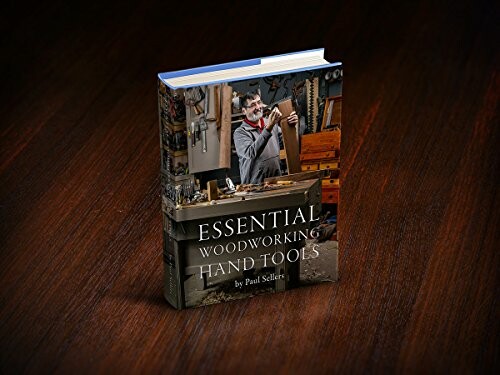 Book titled 'Essential Woodworking Hand Tools' on a wooden table.